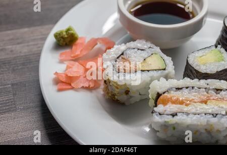 Petits pains à sushis et sandwichs à sushis sur une assiette blanche avec sélection mise au point Banque D'Images