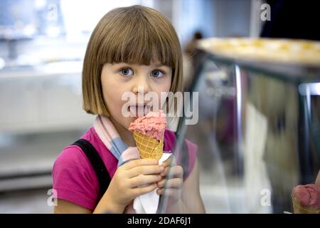 Petite fille en robe d'été manger de la glace sur le magasin: Russie, Moscou - 13 juin 2019 Banque D'Images