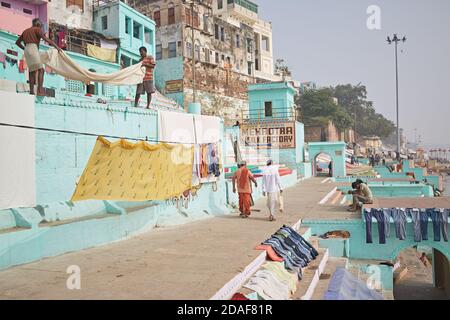 Varanasi, Inde, décembre 2015. Hommes mettant des vêtements à sécher dans un ghat sur le fleuve Ganges. Banque D'Images