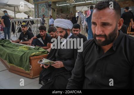 Najaf, Irak. 12 novembre 2020. Les gens prient à côté d'un cercueil à la mosquée de l'Imam Ali dans la ville sainte chiite de Najaf. La mosquée de l'Imam Ali abrite le tombeau d'Ali ibn Abi Talib, cousin du prophète Mahomet et du quatrième Caliph dans l'Islam, et considéré comme l'une des plus grandes mosquées du monde. Credit: Ameer Al Mohmedaw/dpa/Alamy Live News Banque D'Images