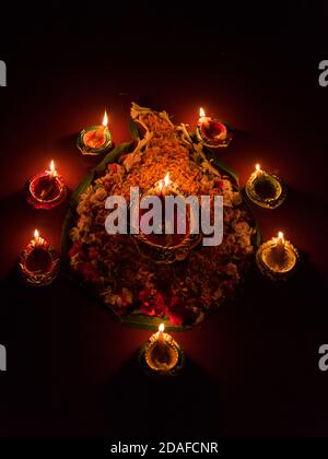 Vue de dessus de Diya ou lampes avec des décorations florales Pour l'occasion de Diwali Banque D'Images