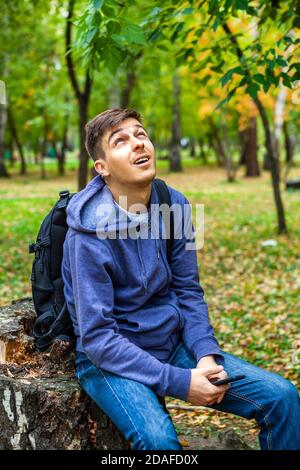 Un jeune homme heureux dans la forêt d'automne seulement Banque D'Images