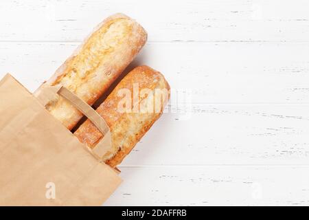 Pain de baguette dans un sac en papier. Vue de dessus du plan de travail avec espace de copie Banque D'Images