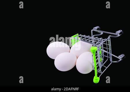 Vue rapprochée du panier avec œufs blancs sur fond noir. Est. Nourriture. Shopping. Banque D'Images