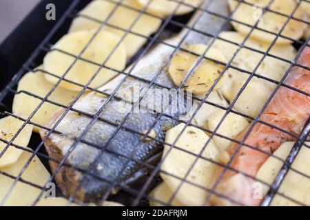 Truite et pommes de terre sur un grill Banque D'Images