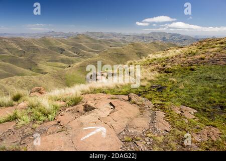 Vue sur les montagnes du Drakensberg de l'État libre, en Afrique du Sud, par une journée ensoleillée claire, avec une flèche peinte au premier plan indiquant la direction de a Banque D'Images