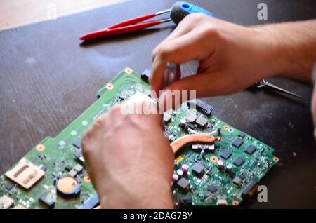 L'homme main du technicien assembler à l'intérieur de la tablette par tournevis dans le laboratoire. Le concept de matériel informatique, téléphone mobile, électronique Banque D'Images