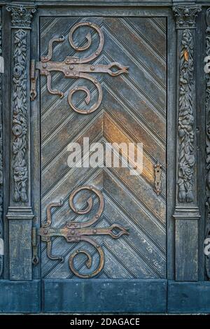 Ancienne porte en bois vintage de style baroque avec charnières en fer et ornements de cadre. Cathédrale de Szczecin, Pologne Banque D'Images