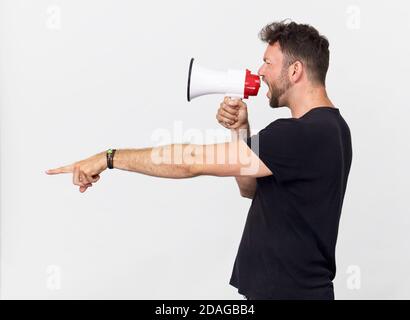 Homme en t-shirt noir criant et motivant à travers le mégaphone Banque D'Images