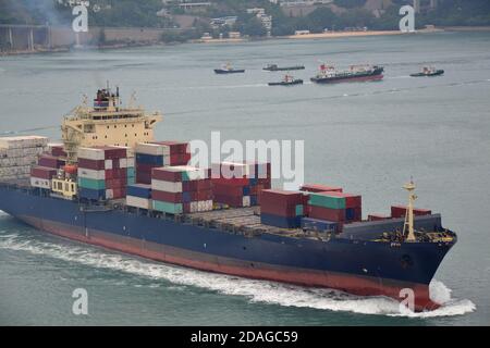 Grand navire lourd à conteneurs bleu et rouge dans le port de Hong Kong Banque D'Images