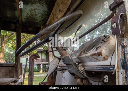 Une ancienne cabine de camion en rondins rouillée avec volant de direction de voiture. Voiture abandonnée, sélectionnez Focus. Banque D'Images