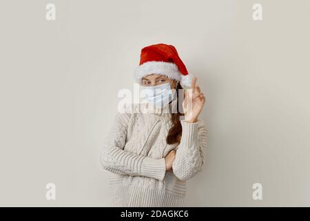 Femme portant un masque de protection pointant avec la main et le doigt vers le haut sur le côté Banque D'Images