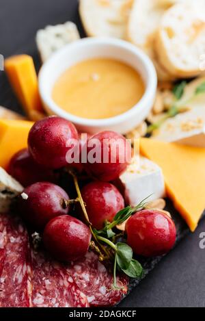 fromages et viandes coupés sur fond noir Banque D'Images