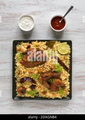 Poulet Mandi avec des dates sur une table blanche. Cuisine arabe. Vue de dessus. Banque D'Images