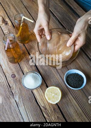Kombucha en fermentant le thé avec culture symbiotique de bactéries et de levure sur table en bois. Banque D'Images