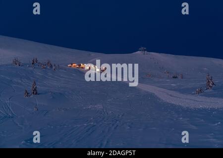 Snow groomers (machines de ratrack de chat de neige) lors d'une excursion nocturne avant l'aube jusqu'au sommet de montagne d'hiver avec des freeriders snowboarders. Dragobrat, Ukraine. Péop Banque D'Images