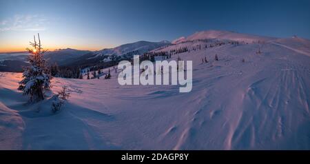 Pittoresque lever de soleil sur les alpes d'hiver. La plus haute crête des Carpates ukrainiens est Chornohora avec des sommets de Hoverla et Petros. Vue de Svydov Banque D'Images