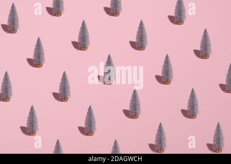 Motif sur fond rose avec des arbres de Noël argentés. Concept de Noël ou de nouvel an minimal. Banque D'Images