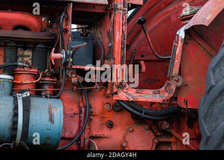 Vue en gros plan latérale de l'ancien moteur de tracteur rouge rouille vintage détails abstraits avec graisse nette à mise au point sélective vieillie Banque D'Images