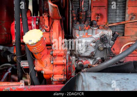 Vue en gros plan latérale de l'ancien moteur de tracteur rouge rouille vintage détails abstraits avec graisse nette à mise au point sélective vieillie Banque D'Images