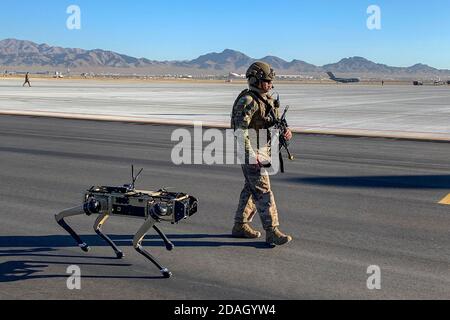 U.S. Air Force Tech. Sgt. Johnny Rodriguez se promène le long du véhicule au sol sans pilote Ghost Q-UGV, connu sous le nom de chien robotique, lors d'un exercice de système avancé de gestion de combat à la base aérienne de Nellis le 3 septembre 2020 à Las Vegas, Nevada. Banque D'Images