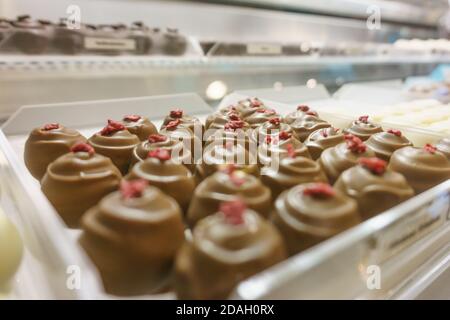 Patern de nombreuses pralines au chocolat aux framboise en vitrine au magasin Banque D'Images