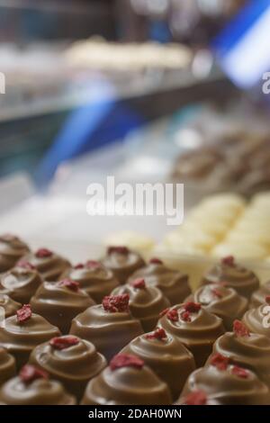 Patern de nombreux pralines au chocolat aux baies de framboise en vitrine stocker Banque D'Images