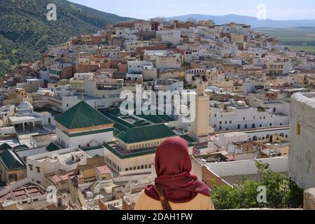 Femme regardant Moulay Idriss dominée par Zaouia (école religieuse), Maroc Banque D'Images