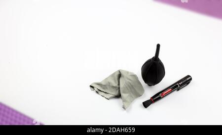 Kit de nettoyage de la caméra (souffleur à poussière, stylo d'objectif et chiffon de nettoyage pour fibres) pour le nettoyage de la caméra. Mise au point sélective sur fond blanc Banque D'Images