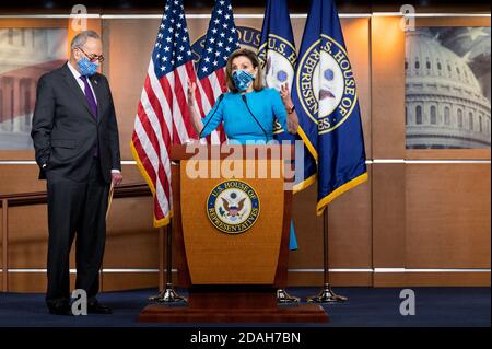 Washington, États-Unis. 12 novembre 2020. La Présidente de la Chambre Nancy Pelosi (D-CA) portant un masque facial parle avec le leader du Sénat minoritaire Chuck Schumer (D-NY) qui se tient à côté d'elle lors d'une conférence de presse. Crédit : SOPA Images Limited/Alamy Live News Banque D'Images