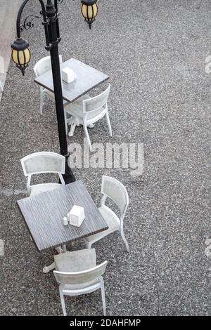 vider les tables dans un café de rue pendant une pandémie de virus. Confinement de la ville de New York, quarantaine du coronavirus. Tables de restaurant et de cafétéria vides. Vertical Banque D'Images