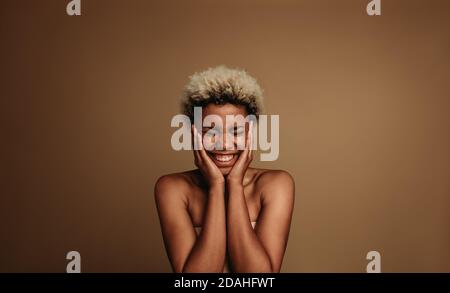 Portrait d'une femme afro-américaine excitée. Bonne femme avec les mains à ses joues dans une humeur excitée. Banque D'Images