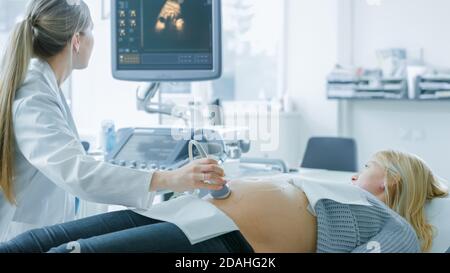 À l'hôpital, la femme enceinte se fait acquérir un échographe, l'obstétricien vérifie l'image du bébé en bonne santé sur l'écran de l'ordinateur Banque D'Images