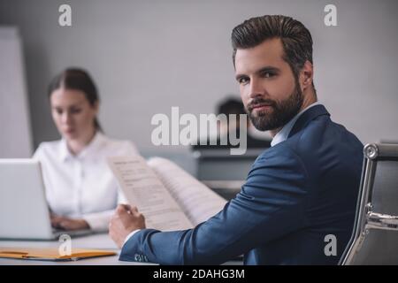 Homme regardant en arrière et femme derrière un ordinateur portable Banque D'Images