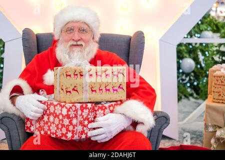 Portrait du vrai Père Noël authentique avec des cadeaux de Noël dans les mains dans le centre commercial. Banque D'Images