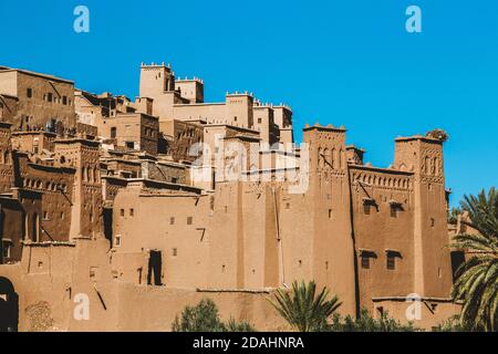 Vue panoramique d'un célèbre village berbère marocain au milieu du désert du sahara contre un palmier et ciel bleu clair, ait Ben Haddou, Maroc, Afrique