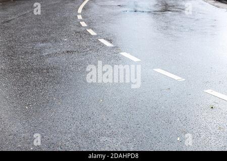 surface humide d'une route à deux voies en ville après la pluie d'automne Banque D'Images