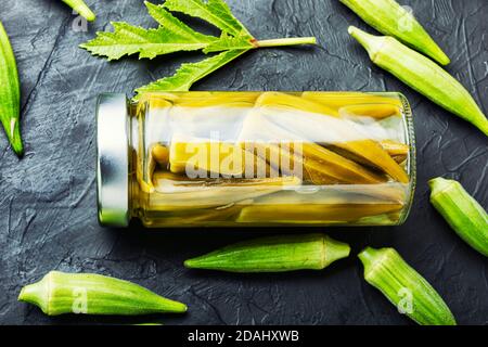 Gousses d'okra en conserve dans un pot en verre. Légumes salés marinés faits maison. Banque D'Images