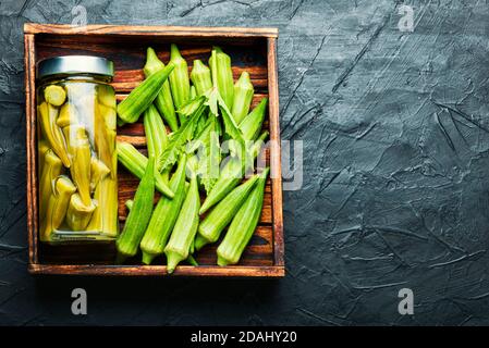 Gousses d'okra en conserve dans un pot en verre. Légumes salés marinés faits maison. Banque D'Images