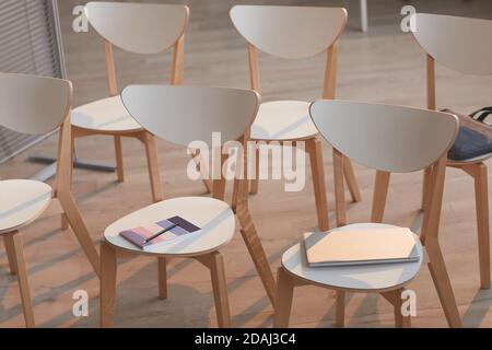 Gros plan de chaises vides en bois avec blocs-notes sur la préparation pour les réunions d'affaires dans la salle du conseil Banque D'Images