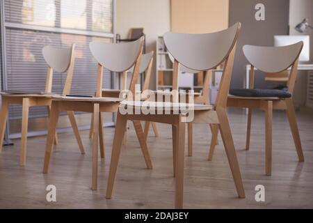 Gros plan de chaises en bois debout à un bureau vide pour la réunion Banque D'Images