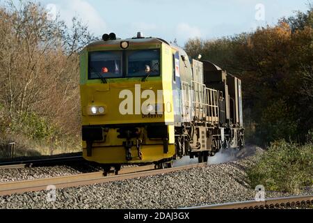 Un monospace de réseau ferroviaire (véhicule polyvalent) nettoyant les rails des feuilles tombées, Warwickshire, Angleterre, Royaume-Uni Banque D'Images