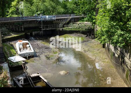 Des méplats de boue et des bateaux à marée basse où le ruisseau Beverley approche de sa confluence avec la Tamise à Barnes. Banque D'Images