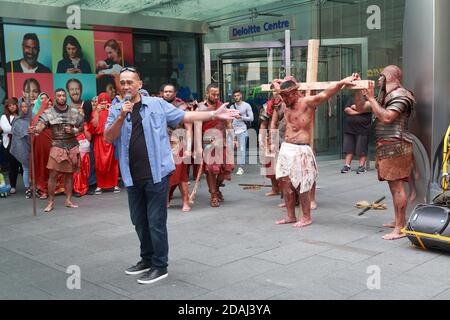 Reconstitution de rue de la Crucifixion de Jésus par des membres d'une église polynésienne à Auckland, Nouvelle-Zélande. Un prédicateur s'adresse à la foule Banque D'Images