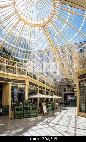 Restaurants et magasins dans le passage des Lions, passage piéton couvert d'un toit en verre dans le centre-ville de Genève. Banque D'Images