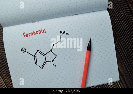 Chimie moléculaire Formule hormone sérotonine écrire sur un livre isolé sur la table en bois. Banque D'Images