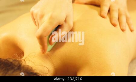 Maître de massage faisant un massage gua sha. Concept spa et massage. Banque D'Images
