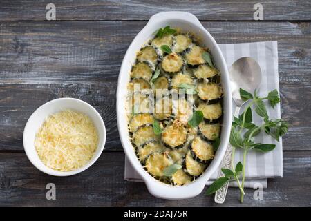 Gratin de courgettes au fromage et aux légumes verts sur fond de bois. Délicieux plats faits maison Banque D'Images