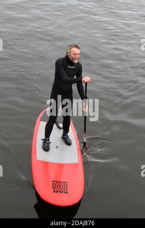 Girvan Harbour, Ayrshire, Écosse, Royaume-Uni ouverture officielle de nouveaux pontons et désignation du skiff de la Grivan academy. Homme en costume mouillé sur planche à pédales Banque D'Images