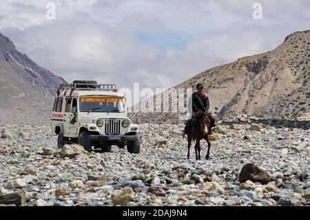 Une jeep touristique et un résident local à cheval Parmi les montagnes de l'Himalaya sur le chemin de la haute Mustang Banque D'Images